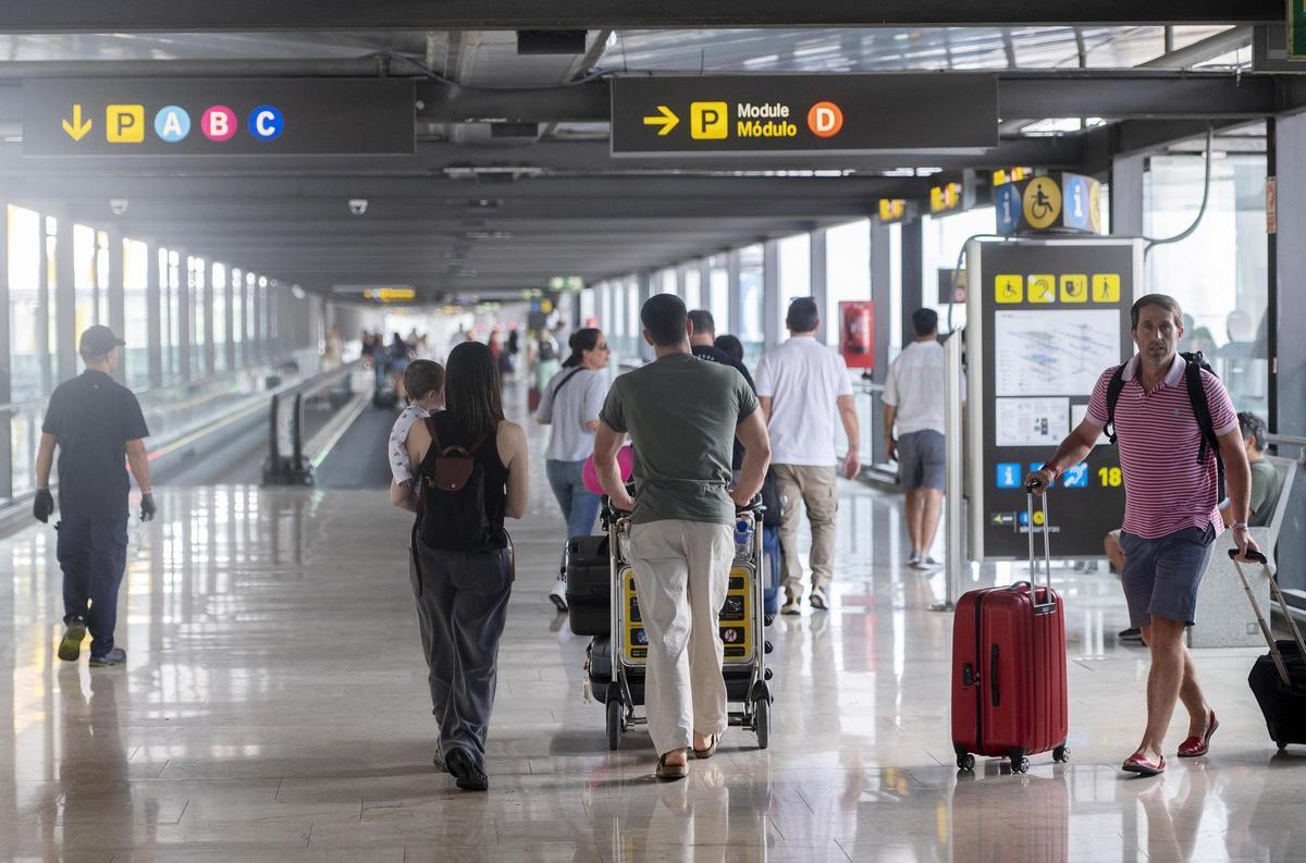 Archivo - Varias personas con maletas en la terminal T4 del aeropuerto Adolfo Suárez Madrid-Barajas.