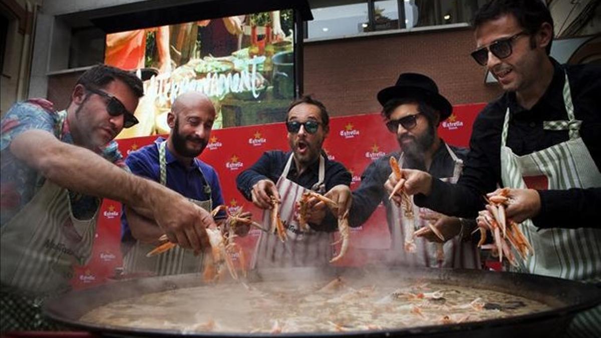 Los integrantes de Love of Lesbian dan el toque final a la paella preparada por el restaurante Suquet de l'Almirall.