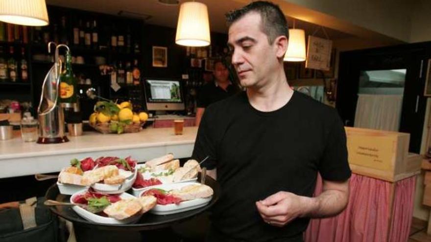 Un camarero de La Olivereta muestra la tapa de Cecina y crema de cabrales con sidra.