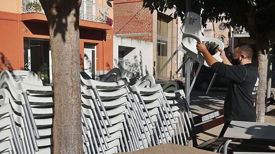 El propietari d&#039;un bar recull les cadires de la terrassa