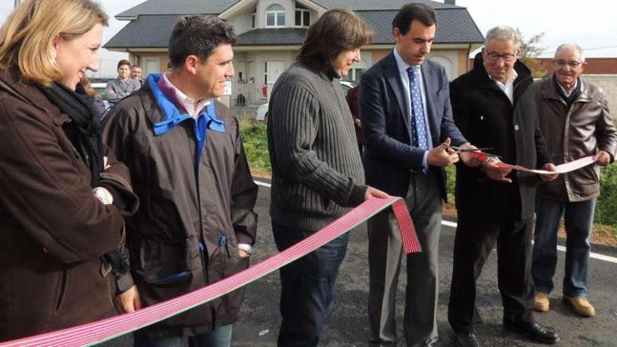 Maíllo corta la cinta de inauguración de las obras de mejora de la carretera. Junto a él, autoridades locales y provinciales.