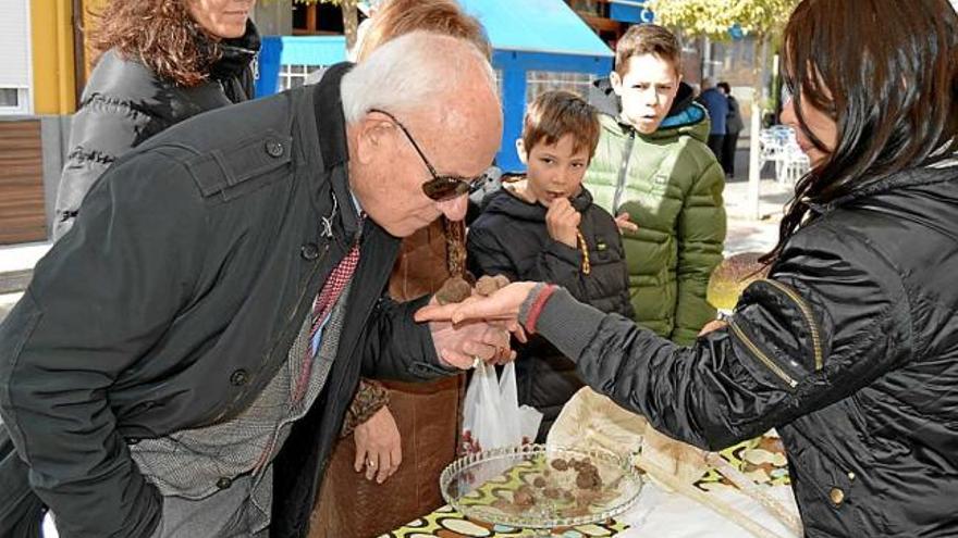 Un visitant olora les tòfones que li ofereix una venedora, ahir