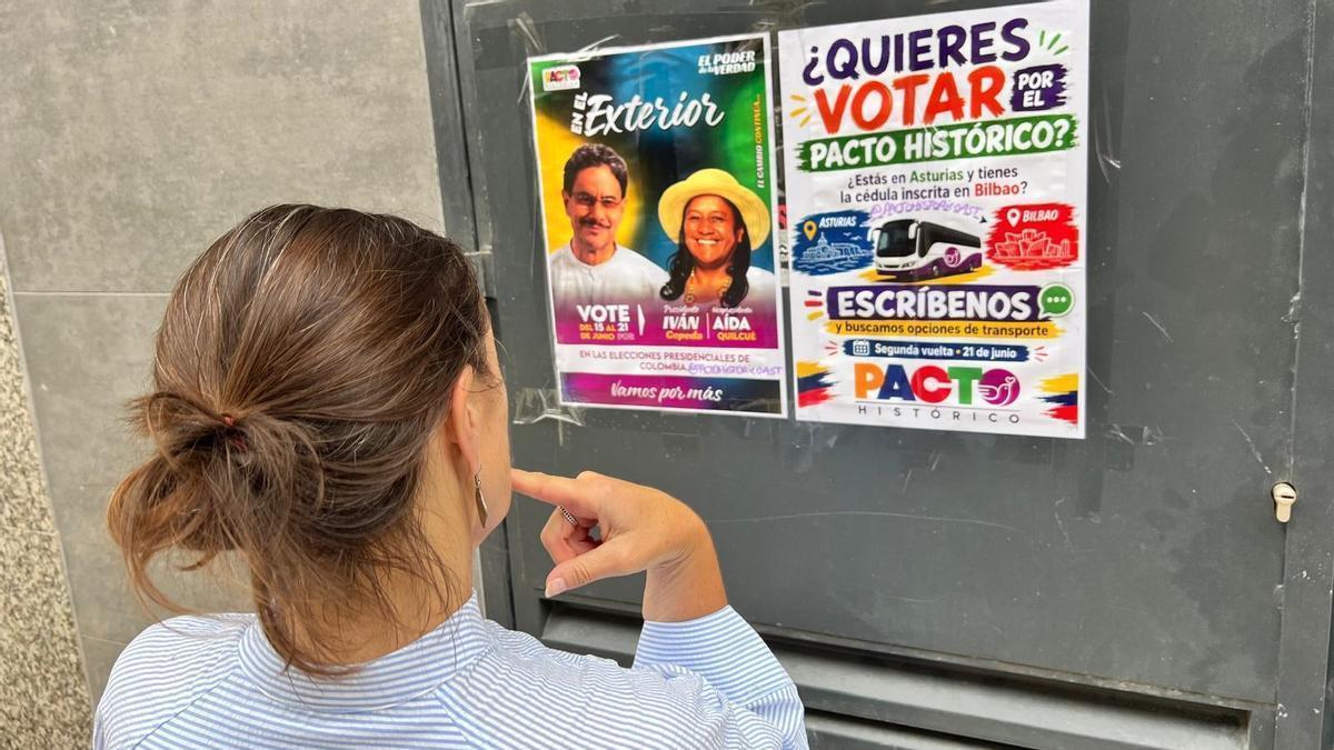 Una mujer observa los carteles invitando a votar en el barrio de Pumarín.