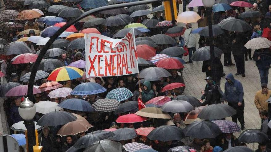 Manifestantes bajo los paraguas, el sábado, en Gijón.