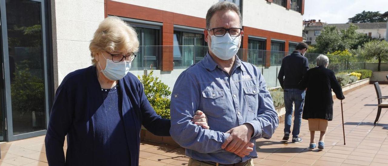 Usuarias y familiares pasean por el exterior de una residencia de Vigo.