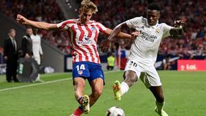 Vinicius Junior y Marcos Llorente disputando un balón en el derbi madrileño liguero.