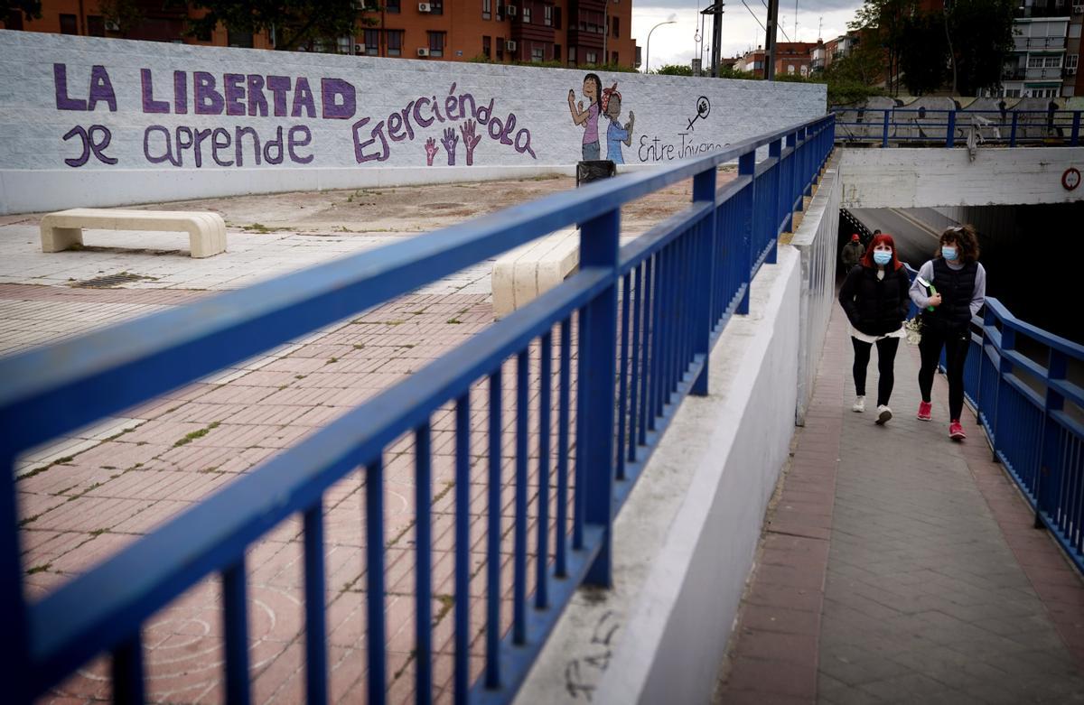 Dos mujeres caminan por el paso subterráneo de la vía del tren en Fuenlabrada.