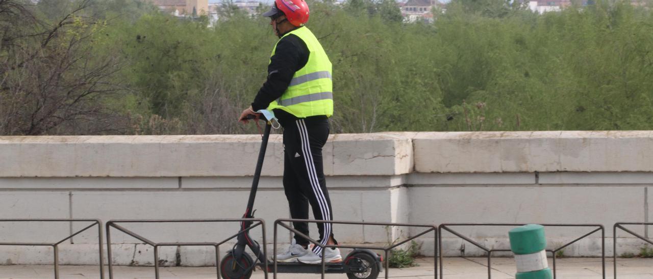 Un hombre circula en patinete eléctrico por una calle de Córdoba.