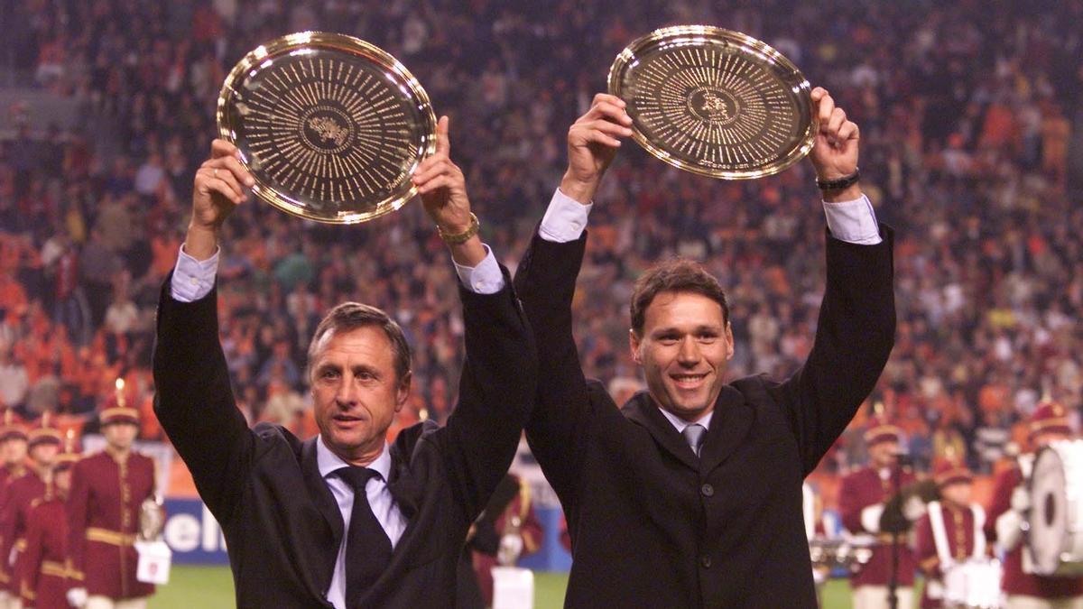 Johan Cruyff y Marco van Basten exhiben sus trofeos como mejores jugadores holandeses del siglo en 1999.