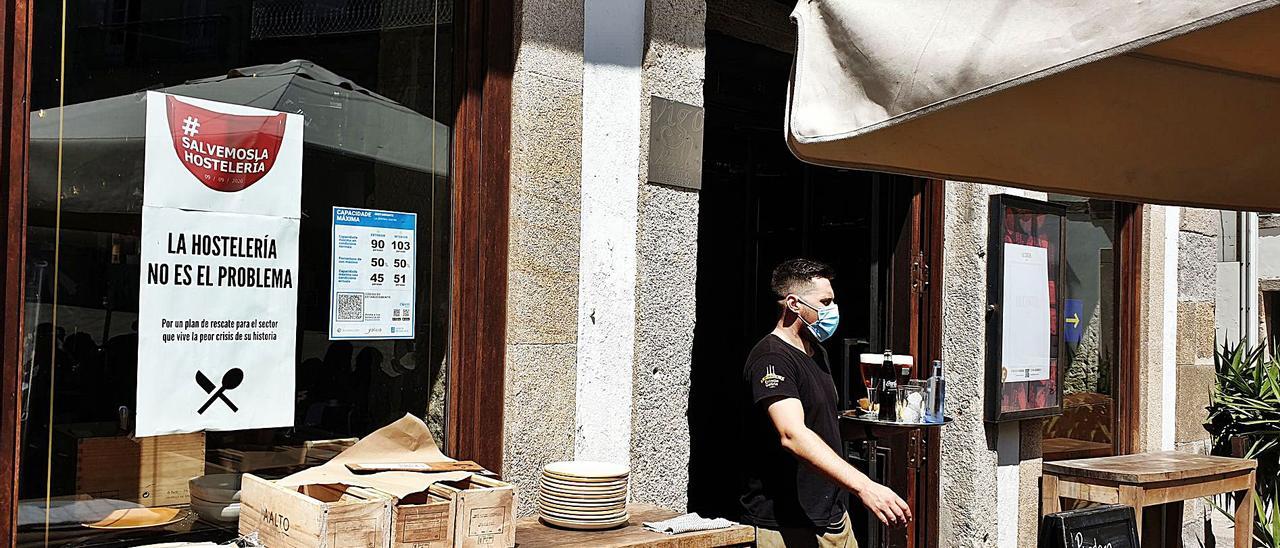 Un camarero sale de un restaurante de la zona vieja de Vigo.