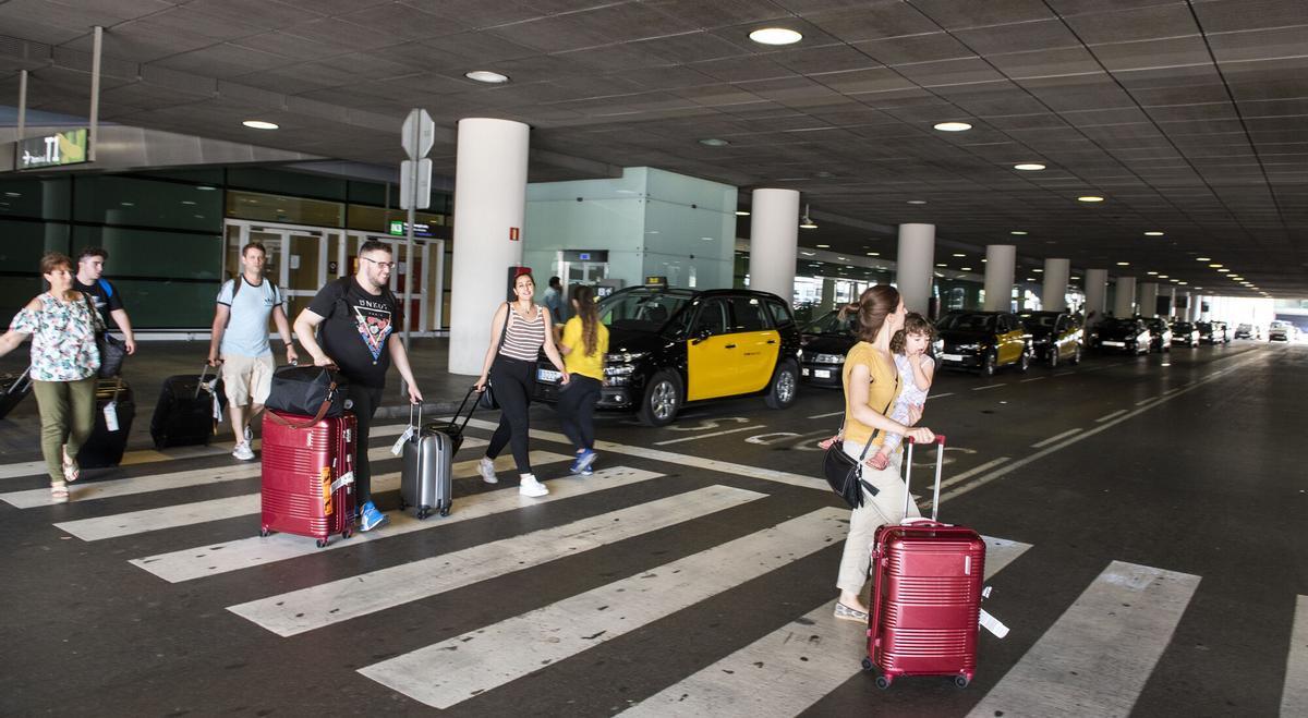 Barcelona. 28.07.2018. Barcelona Una familia de turistas cruza frente a la parada de taxis del aeropuerto de El Prat para buscar otras opciones de transporte tras conocer la huelga indefinida de los taxistas en Barcelona. Fotografía de Jordi Cotrina