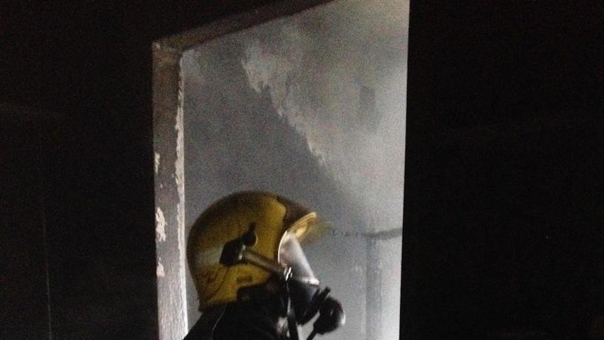 Un bombero, en el interior de la vivienda incendiada.