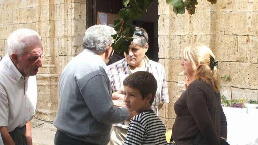 Vecinos admiran la exposición de uvas de una fiesta anterior.