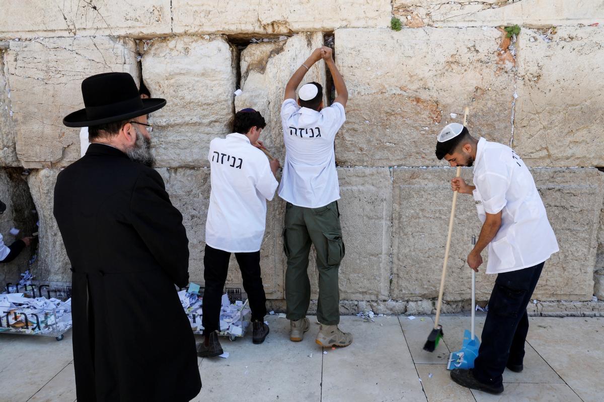 Trabajadores retiran notas de las grietas del Muro de los Lamentos para dejar espacio, como parte de los preparativos previos a la festividad judía de la Pascua, en la Ciudad Vieja de Jerusalén.