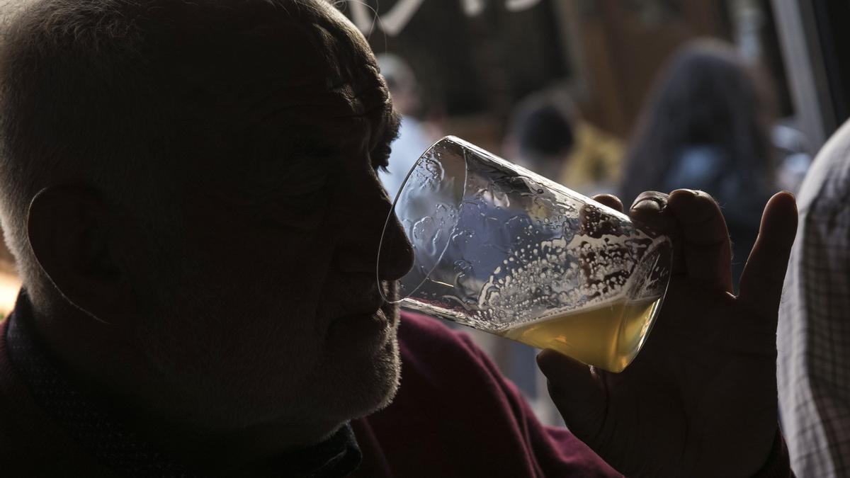 Un hombre prueba bebe un culín de sidra.