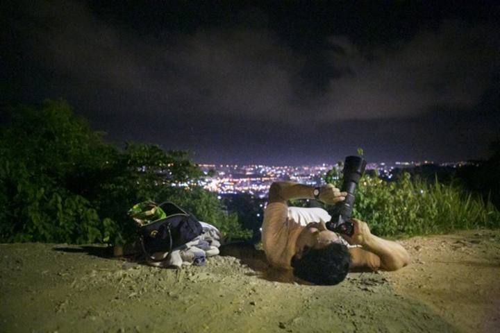 A man takes a photo of the supermoon at Mirador Valle Arriba in Caracas