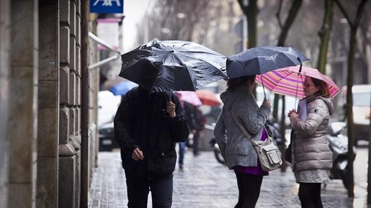 Peatones bajo la lluvia en Barcelona.