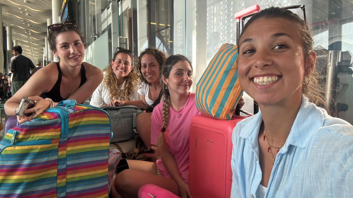 Marina y sus compañeras en un aeropuerto con su equipaje,