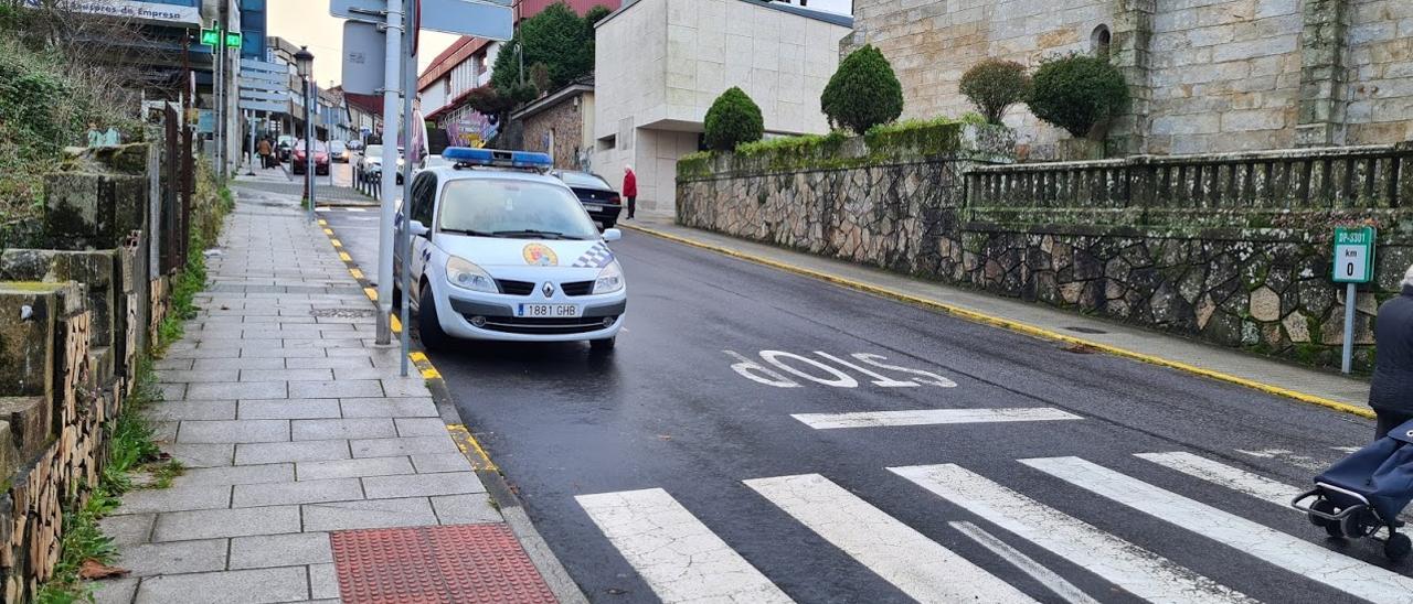 Un vehículo policial y, detrás, la sede el cuerpo, en Rianxo.