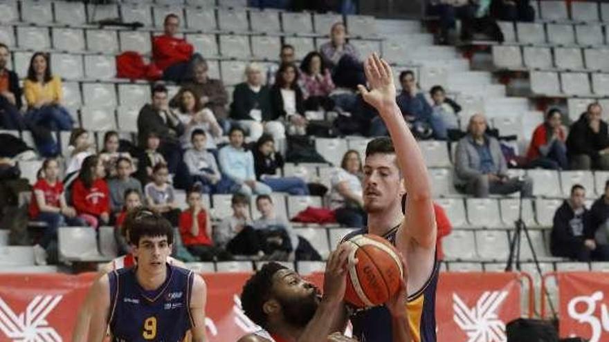 Kenny Ejim trata de superar en la zona a Felipe Braga.