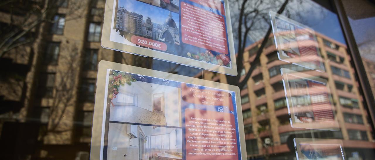 Carteles de viviendas en venta en el escaparate de una inmobiliaria