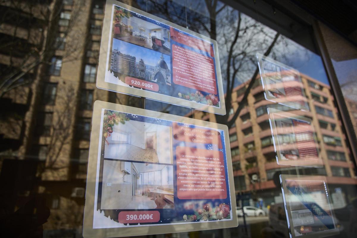Carteles de viviendas en venta en el escaparate de una inmobiliaria.