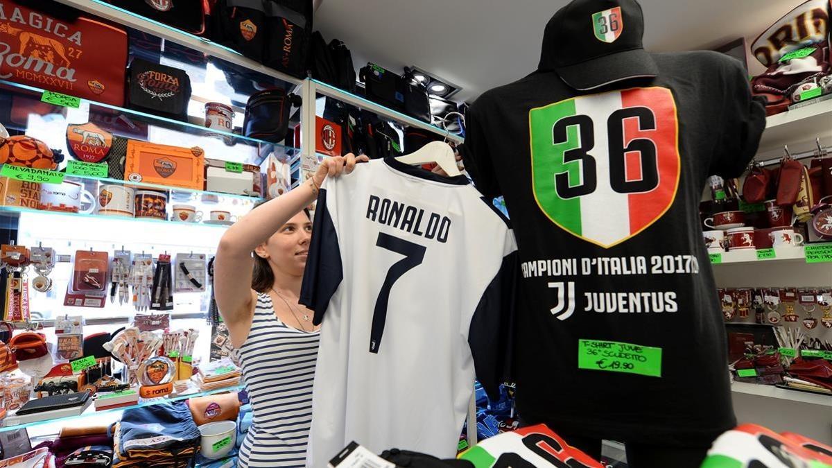 Una vendedora coloca una camiseta de Cristiano con el 7 de la Juventus.