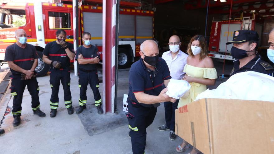 El alcalde de Monóvar y la edil de Seguridad entregando las toñas y el vino a los bomberos.