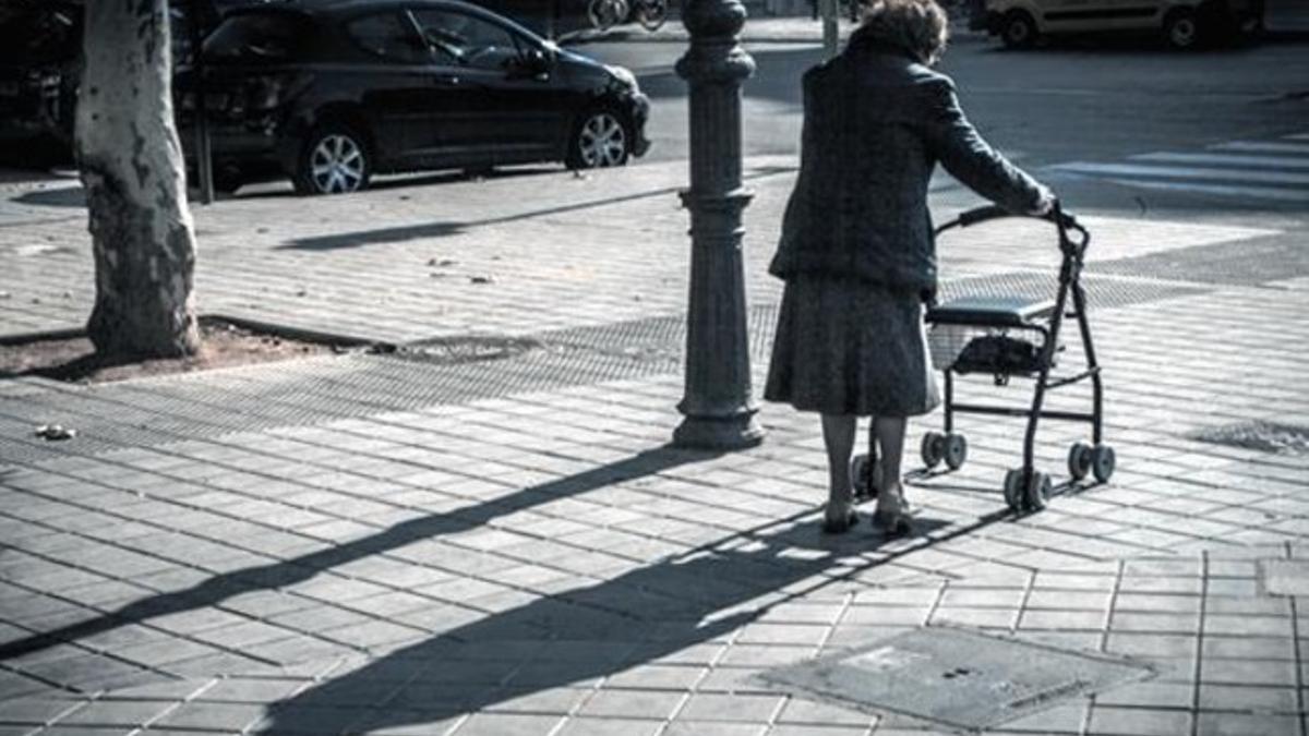 Una anciana camina por una calle de Valencia.