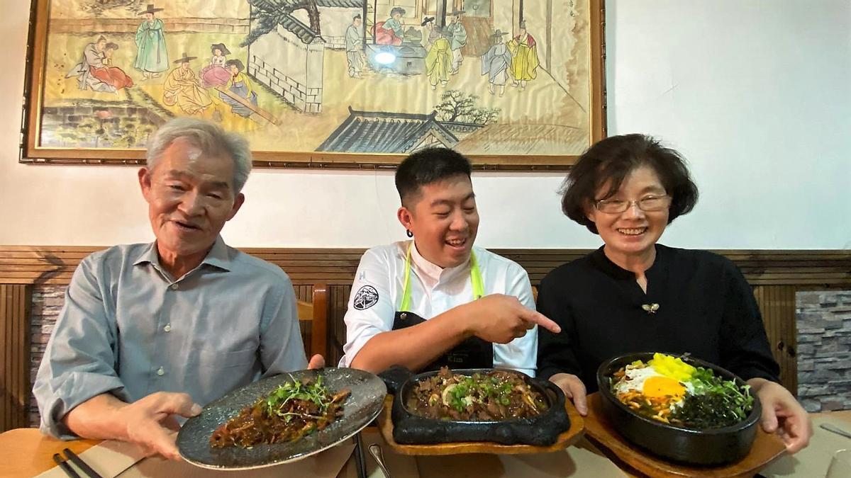 Un San Kim y Myung Chun flanquean a su hijo, Kiwon, en una de las mesas del restaurante San Kil.