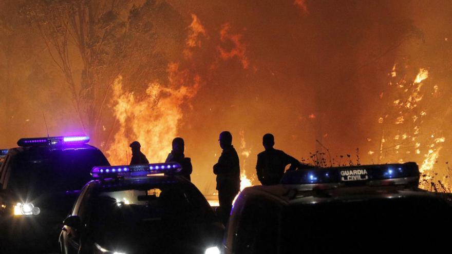 Fuerzas del orden el domingo junto a las llamas en el incendio de Chandebrito (Nigrán).