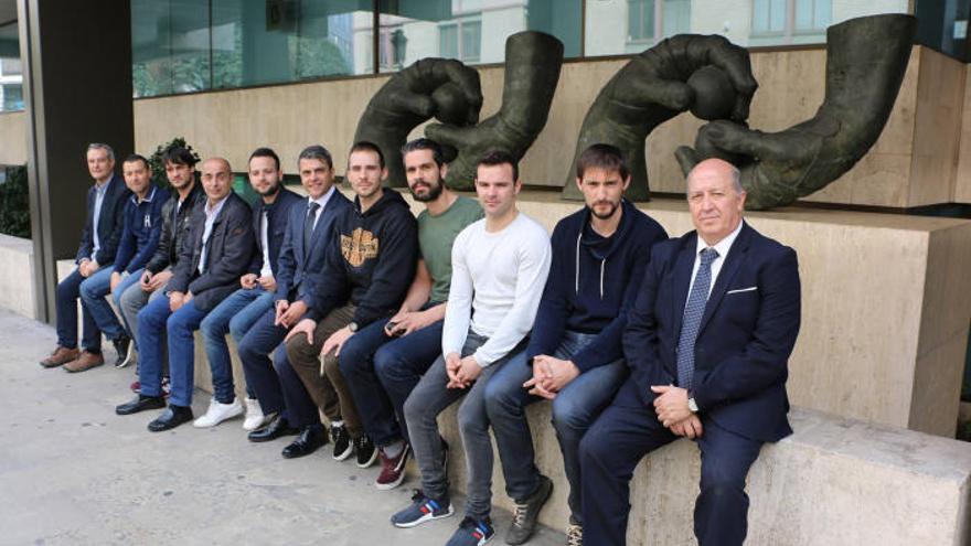 Pilotaris i autoritats posen davant les escultures de ´Les mans´ de l´artista Manuel Boix, situades en l´entrada de la seu de Bankia a València.