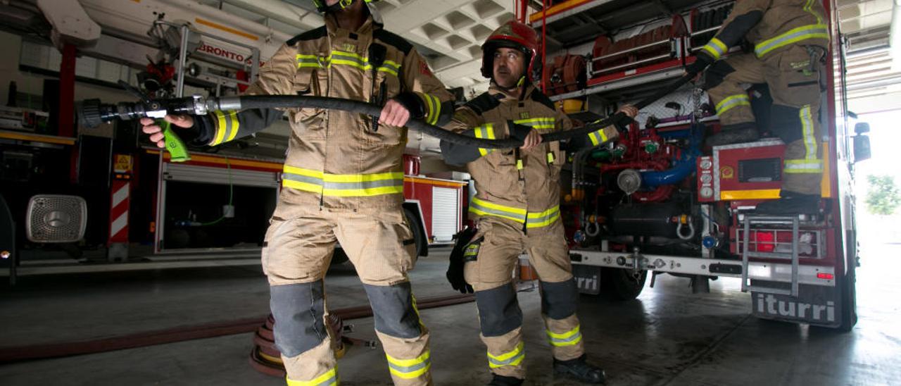 Los Bomberos de Alicante, preparados con los trajes que llevarán esta noche para la «Cremà», en el parque Ildefonso Prats junto a uno de los vehículos.