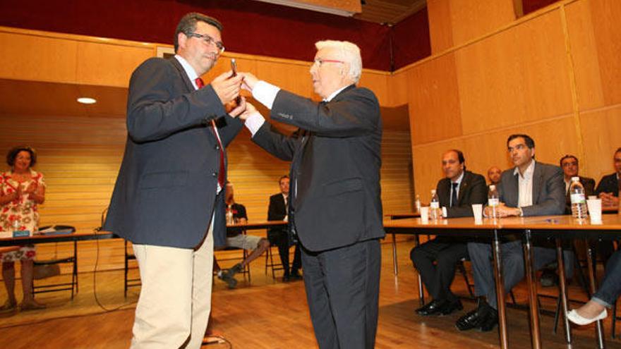 Xaime Rei cede el bastón de mando al popular Javier Bas (i.), ayer, durante el acto de investidura en el Multiusos de A Xunqueira.  // Jesús de Arcos