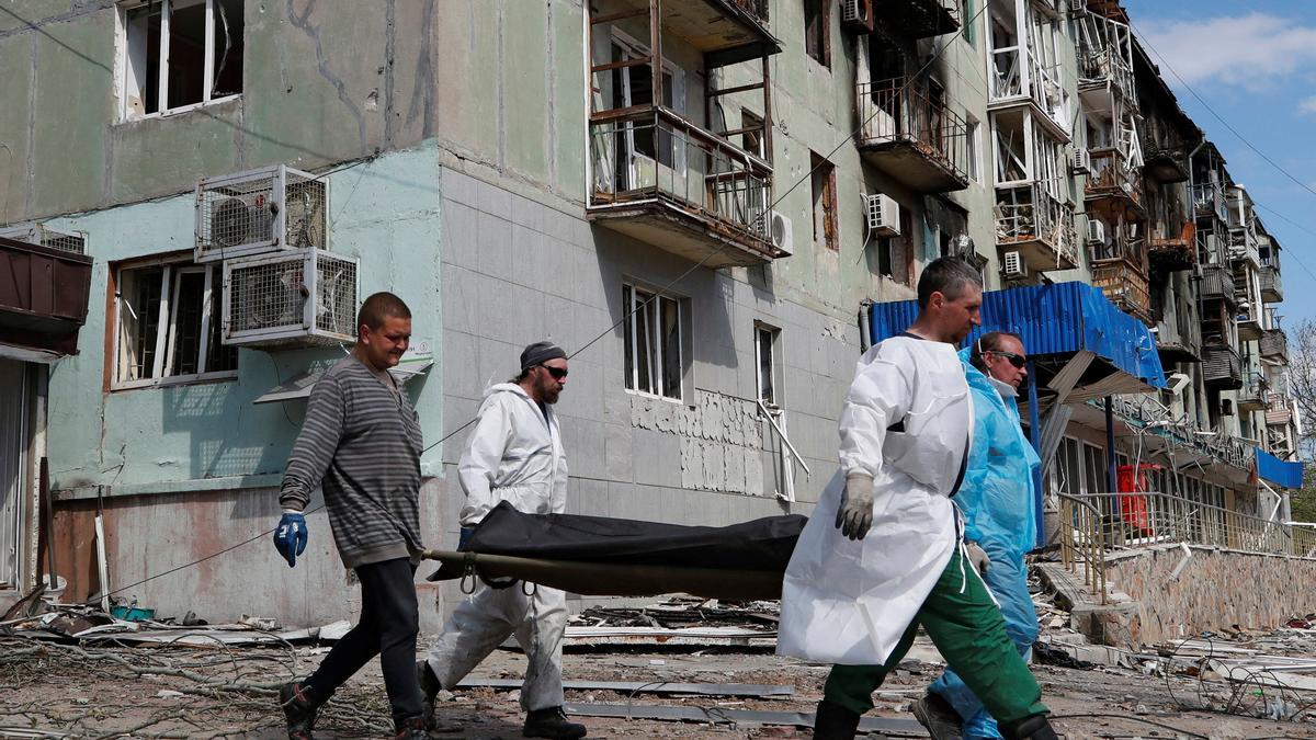 Funeral workers carry the body of a person killed during Ukraine-Russia conflict in Mariupol