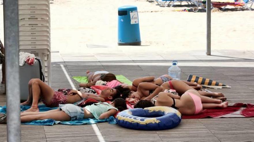 Un grupo de jóvenes duerme en una playa de Benidorm.