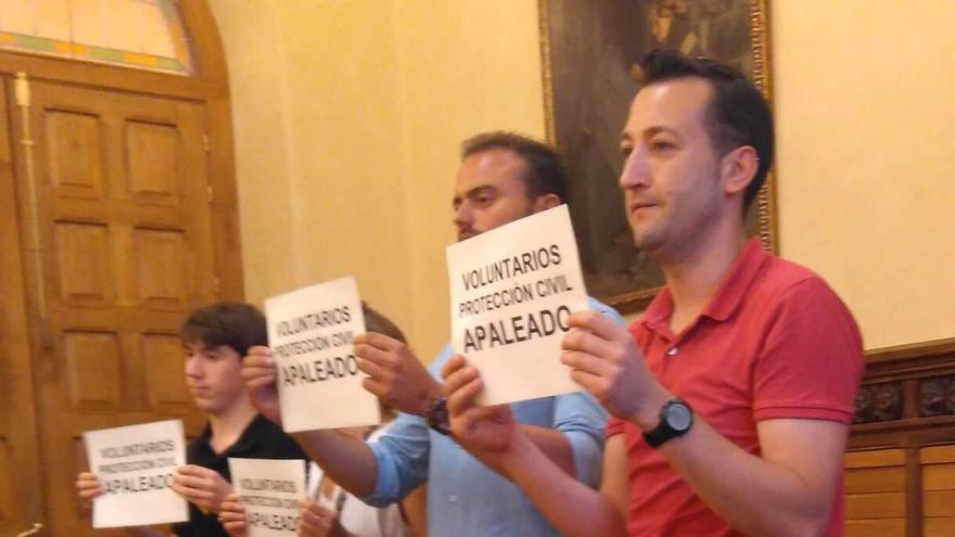 Voluntarios de Protección Civil, con sus pancartas en el salón de plenos.