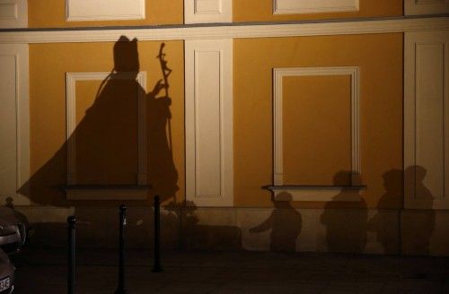 File photo of people casting shadows as they pray in front of a statue of the late Pope John Paul II on the ninth anniversary of his death in Wadowice
