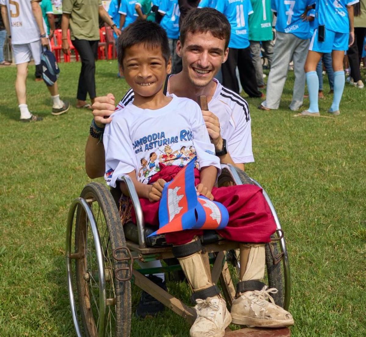 Ignacio de la Vega, junto a un niño en una silla de ruedas en Camboya.