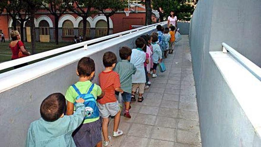Niños agarrados en fila en la entrada de un colegio madrileño.