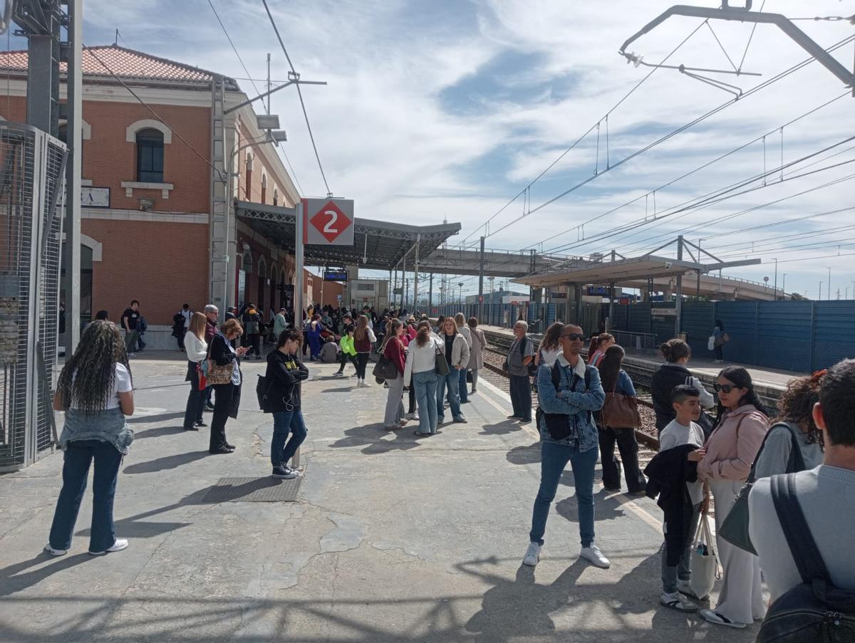 Usuarios de Renfe en la estación de Cercanías de Alzira esperando la llegada del tren.