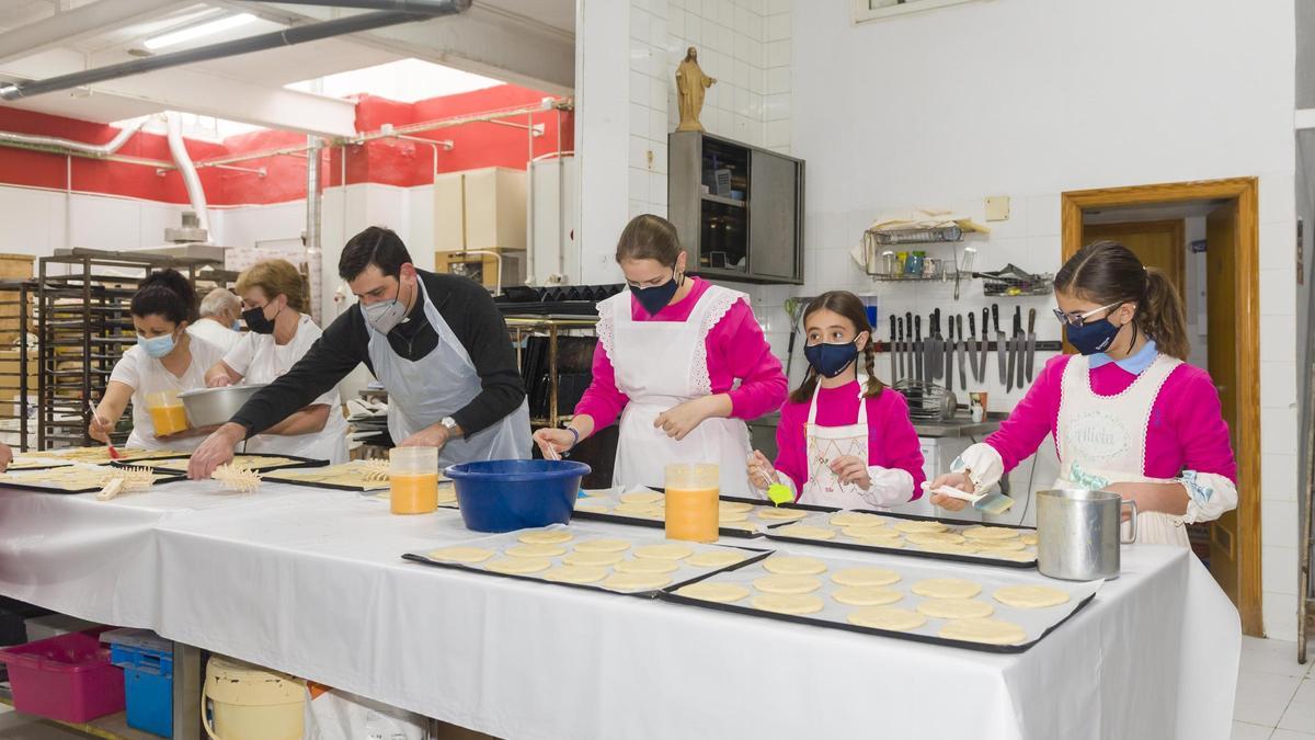 Elaboración de la coqueta en la panadería José María de Benicàssim, con la presencia de las reinas y damas de las fiestas.