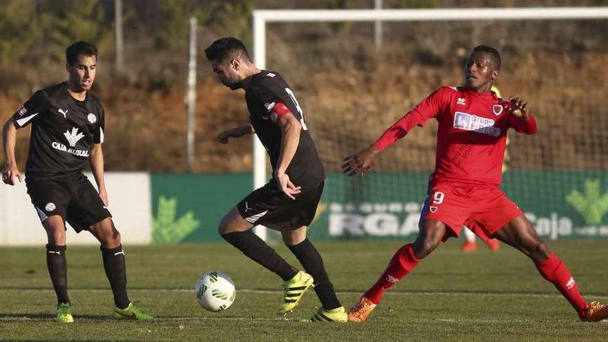 Diego Ortiz y Revi (con el balón), durante el encuentro de ayer en Soria.