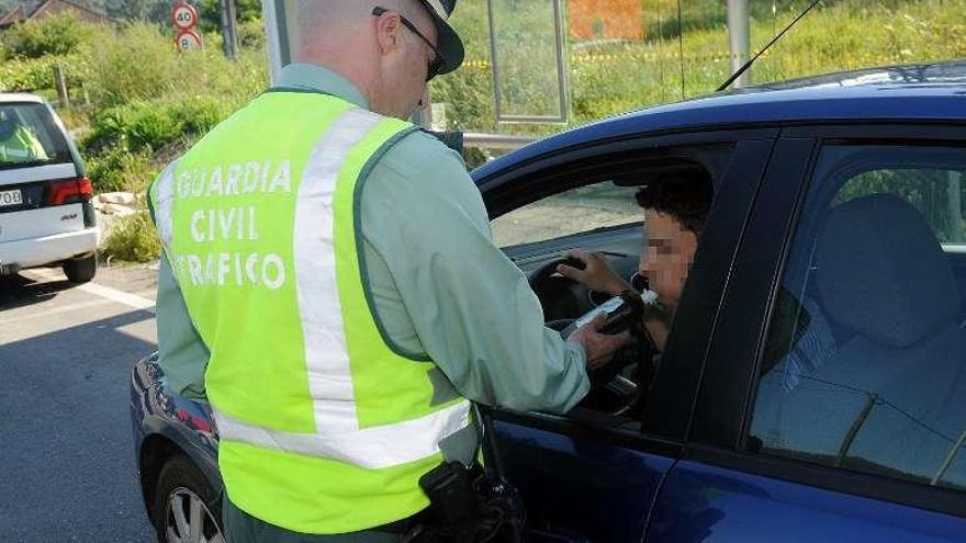 Un agente practica un control de alcoholemia a un conductor. // R. V.