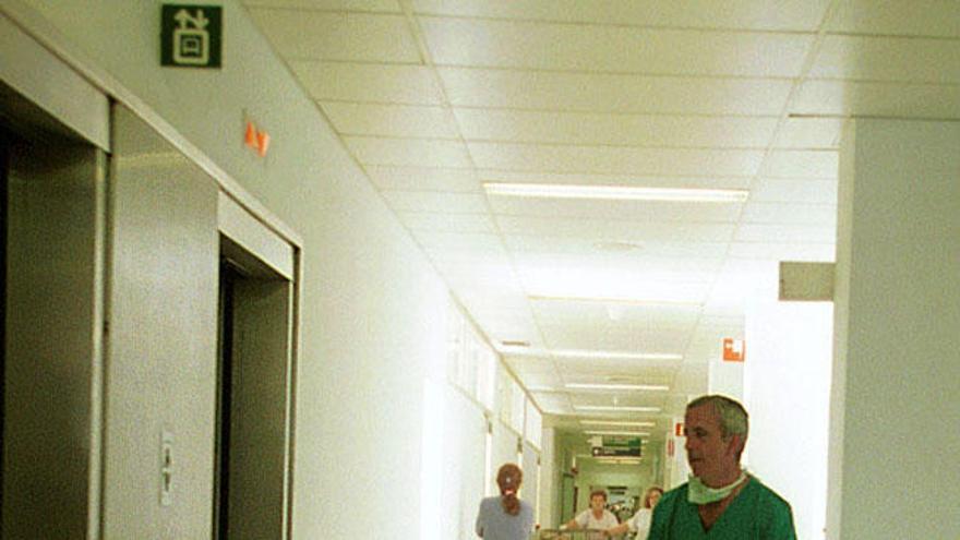 Un sanitario traslada a un paciente en el Hospital Clínico.