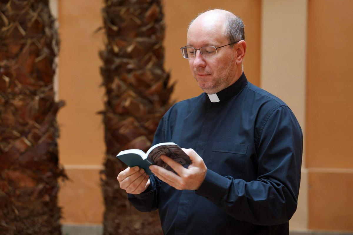 El delegado diocesano de Liturgia, el párroco Edgar Esteve, hojeando el libro con los textos del Evangelio en valenciano.
