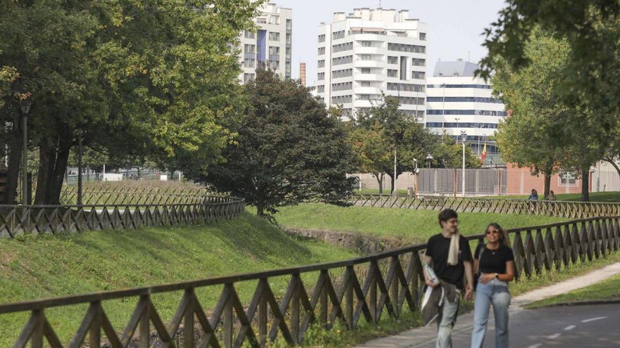 Paseantes en el parque de Moreda, con edificios de Poniente al fondo. | PABLO SOLARES