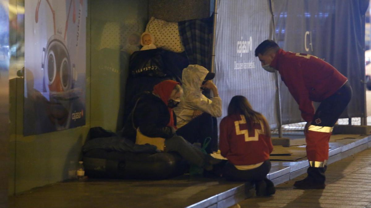 Voluntarios de Cruz Roja atienden a una pareja en Córdoba que duerme en la calle.