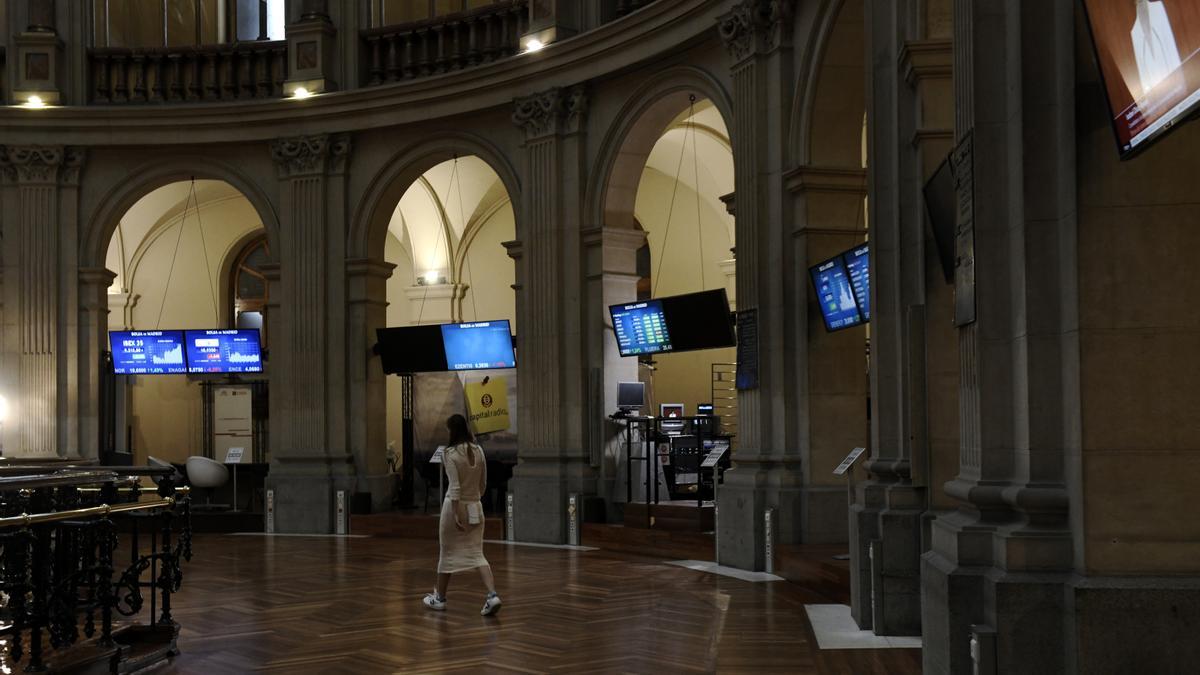 Una mujer camina por el interior de la Bolsa de Madrid.