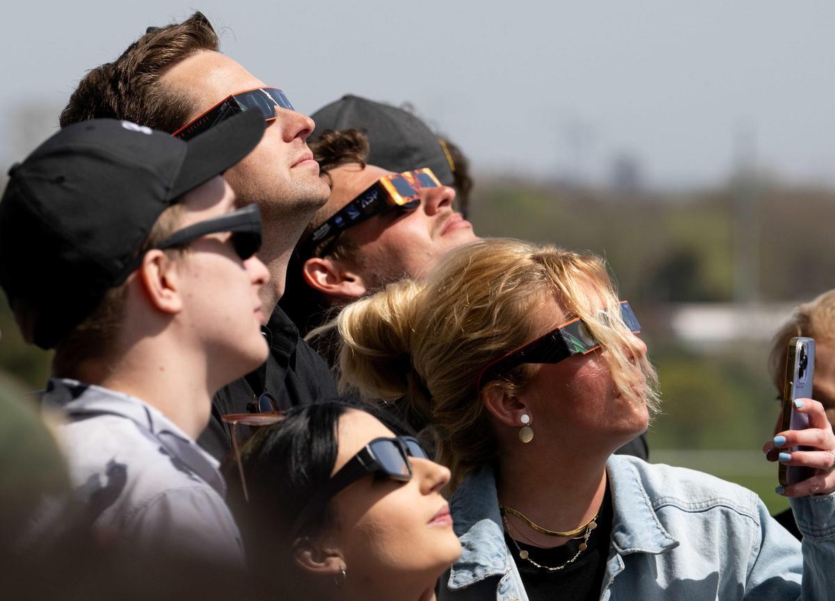 Personas siguiendo un eclipse.